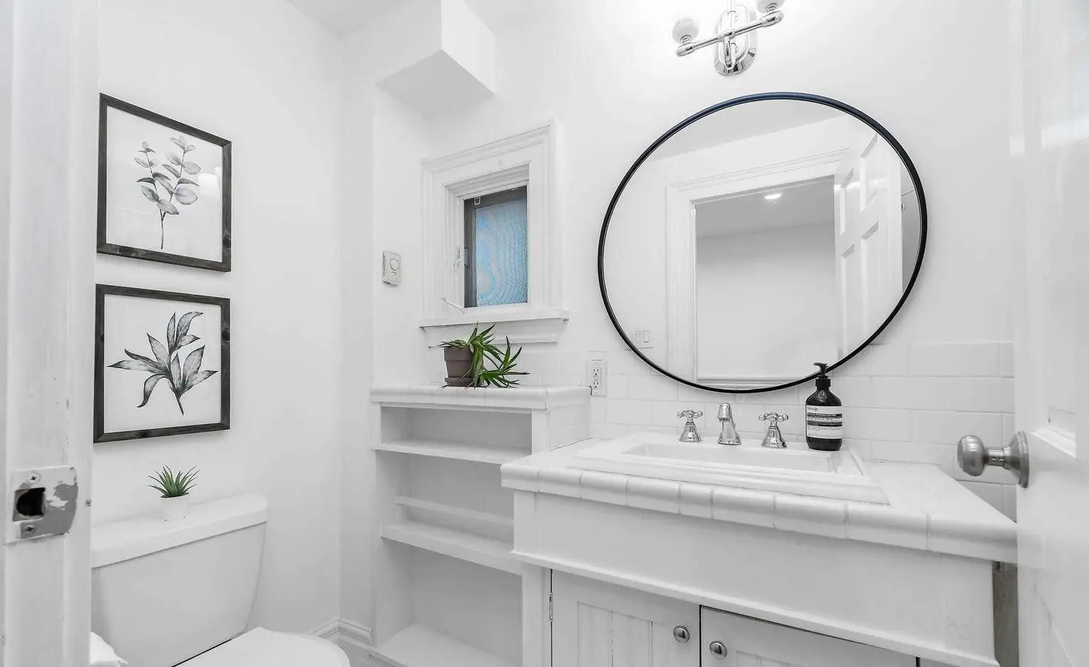 Bathroom with a round black mirror and white vanity