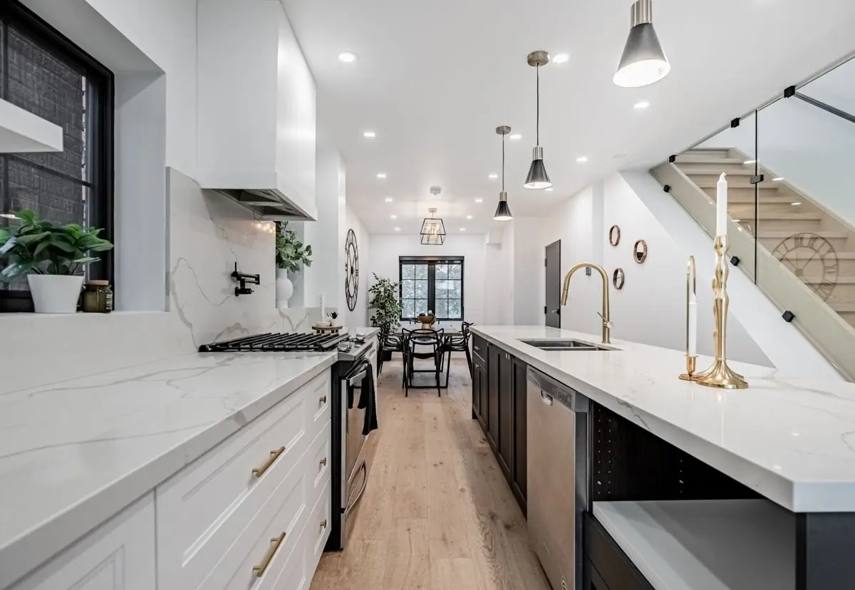 Long galley kitchen with a staircase beyond