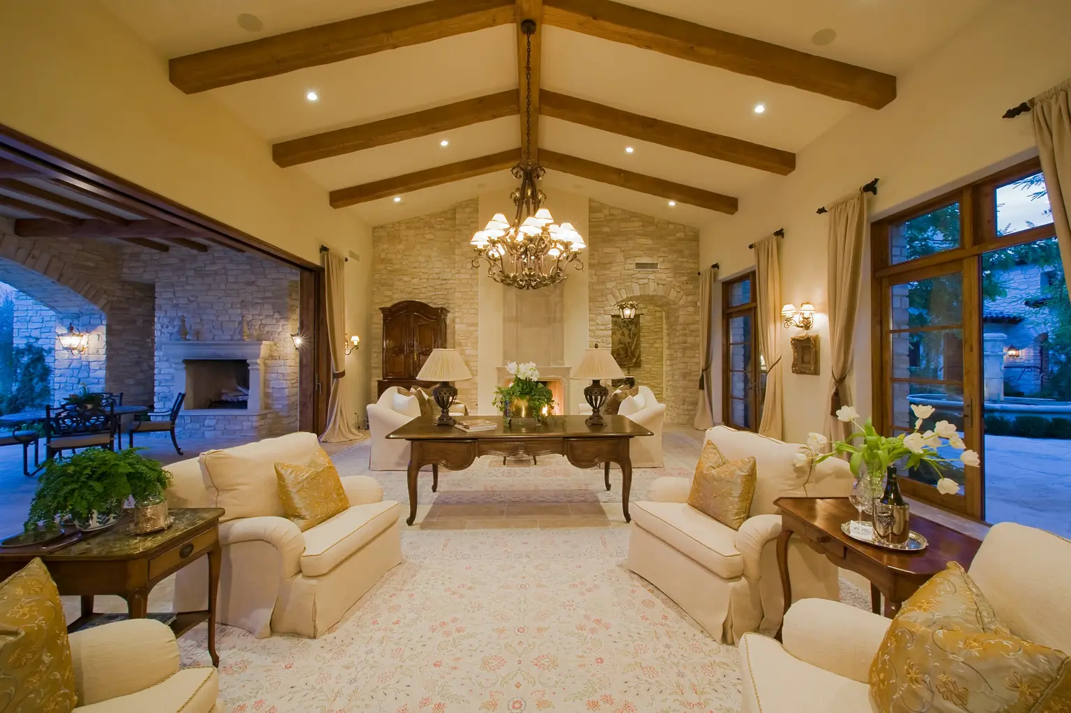 Great room with exposed beams and a chandelier