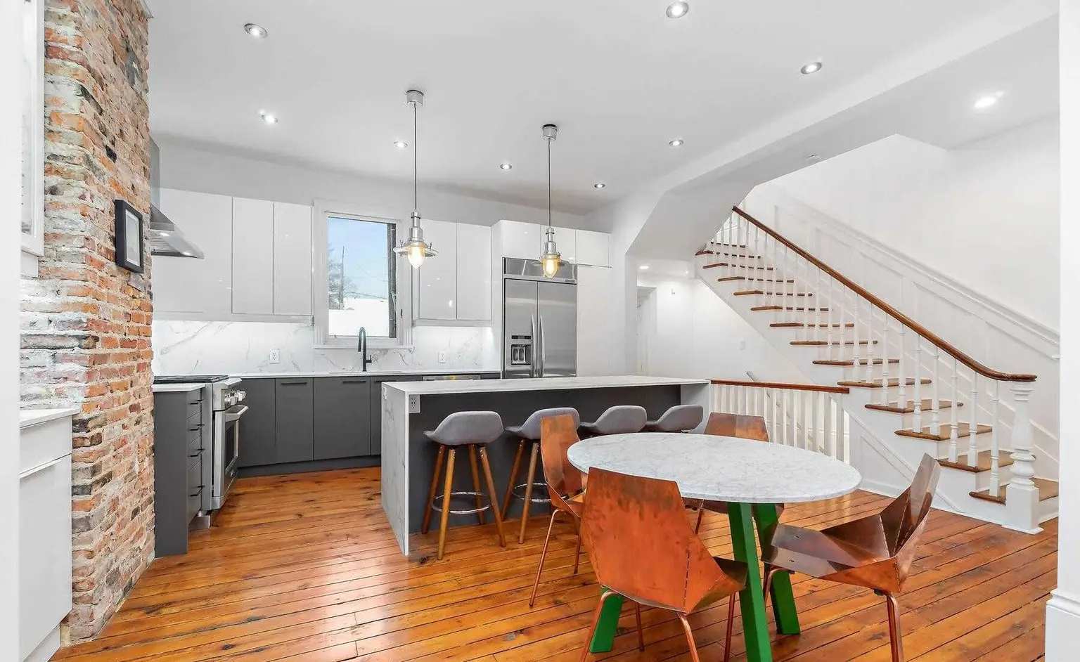 Open kitchen with an island and feature staircase