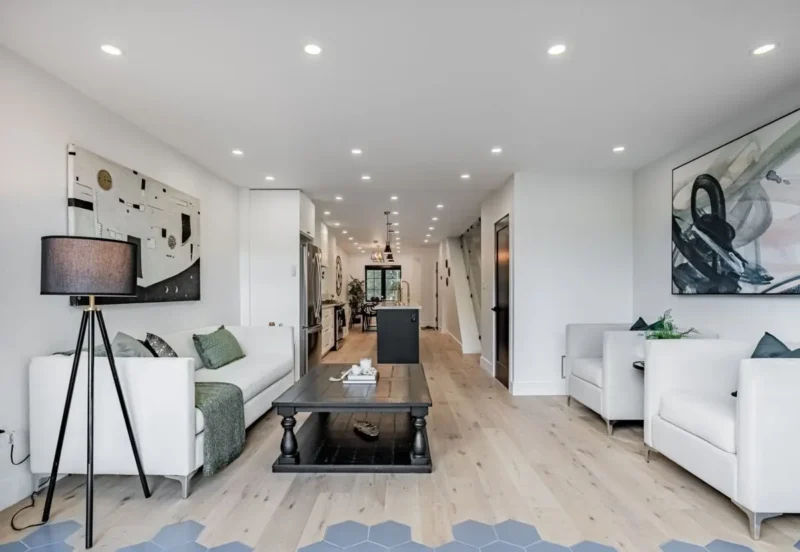 Hallway view through a bright living room and kitchen