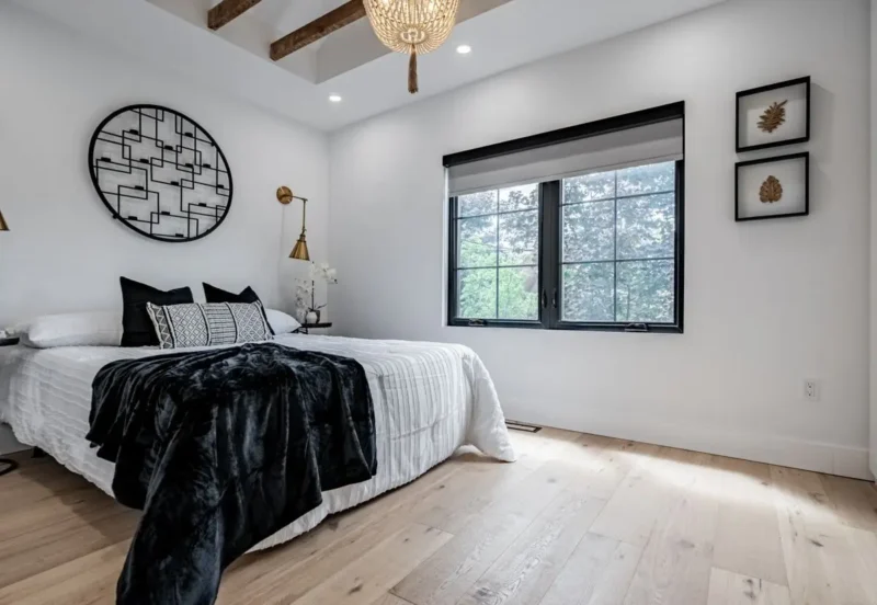 Bedroom with a black-framed window and exposed beam